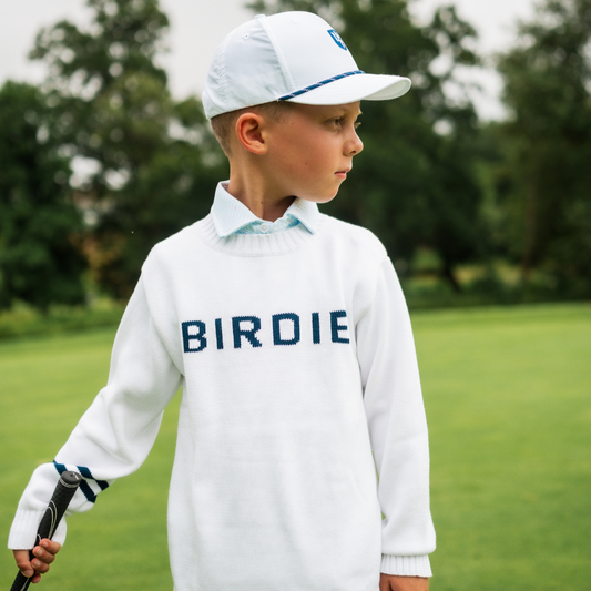 Boy wearing white golf sweater with birdie written across the chest