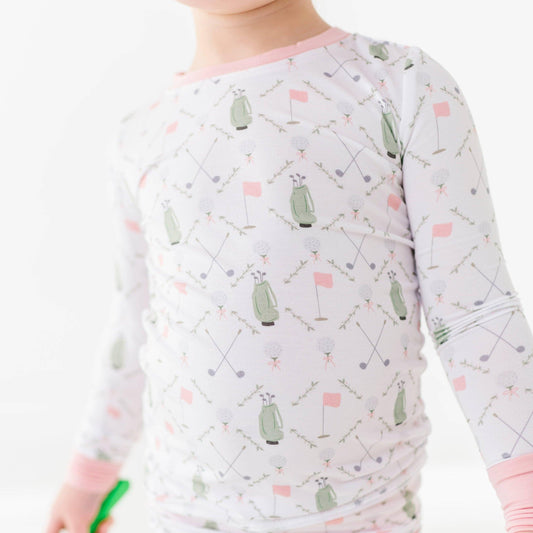 detail shot of girls golf pajamas white with pink pin flags and green golf bags