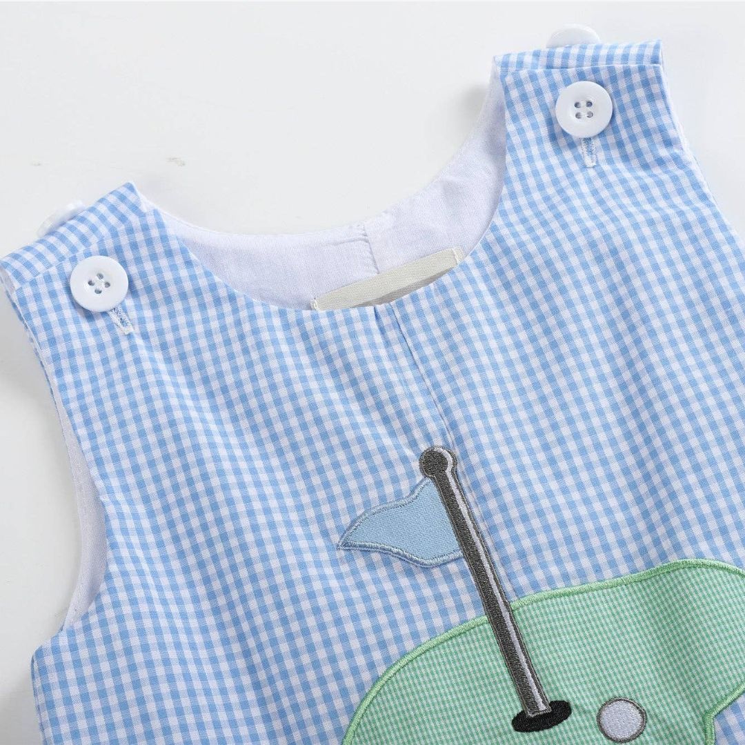 Front close-up of blue gingham baby shortall with embroidered golf hole appliqué
