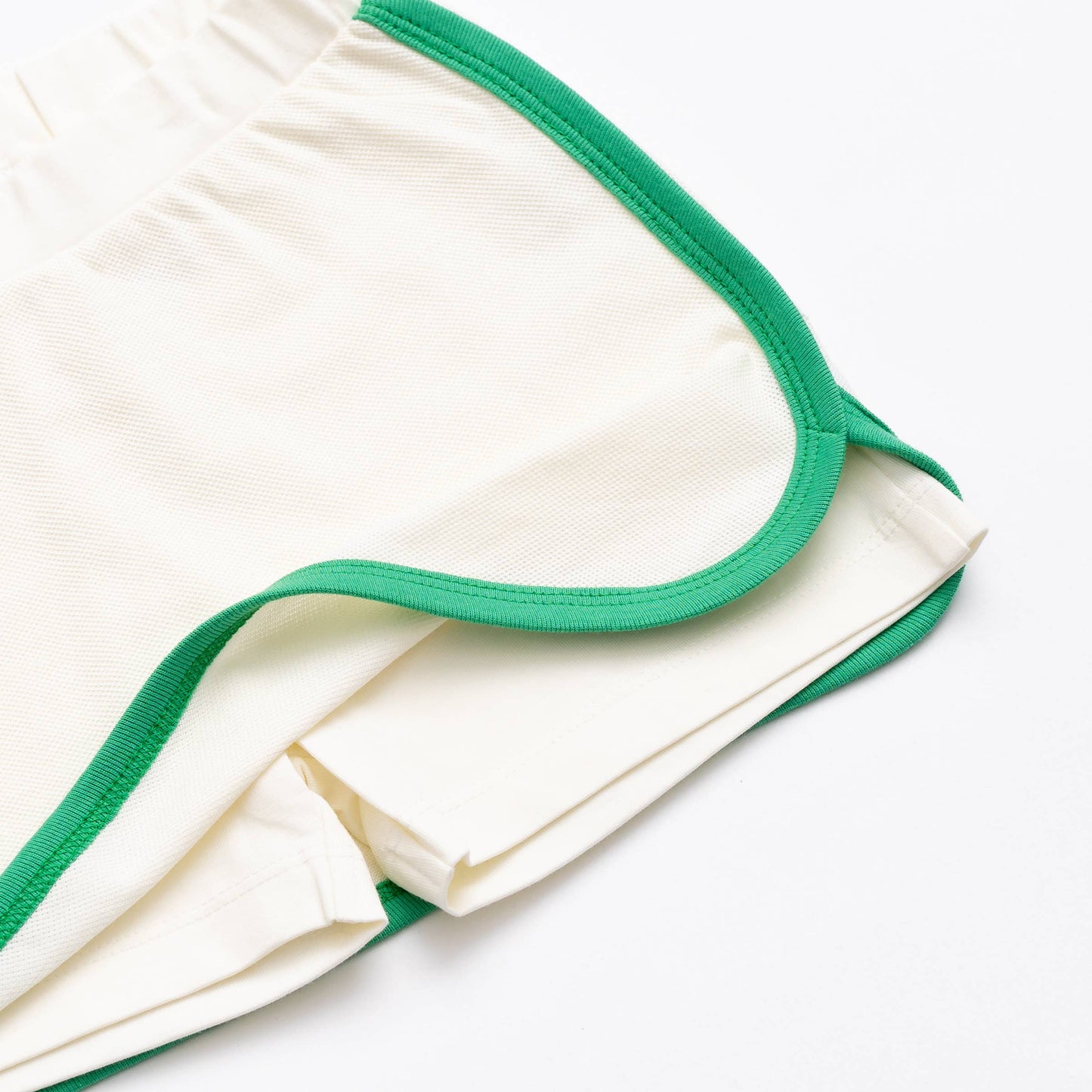Girls white skort with green trim. Front is flipped up so that you can view the shorts underneath.