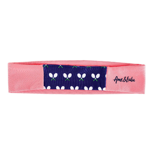 Pink stretch athletic headband with navy tennis racket print panel and Ame & Lulu logo