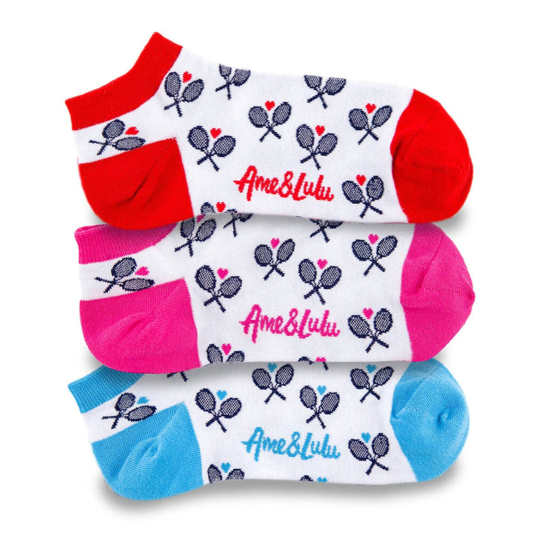 Three pairs of patterned ankle socks stacked in red, pink, and blue with tennis racket design and logo visible