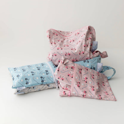 Set of 3 wet/dry bags with golf cart pattern on  white background. Bags are pink, blue, and grey.