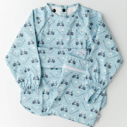 Long sleeved blue bib with golf cart pattern. Shown on a white background with wet/dry bag