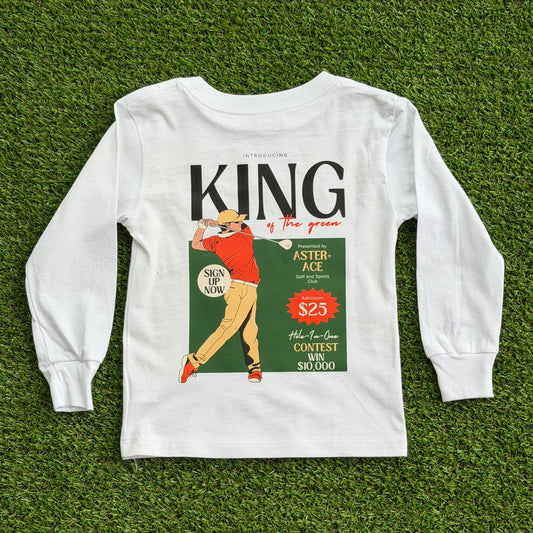 Back of boys’ long sleeve white golf t-shirt featuring a vintage-style “King of the Green” graphic with a golfer in red and tan swinging a club, set against a green background with retro text details.