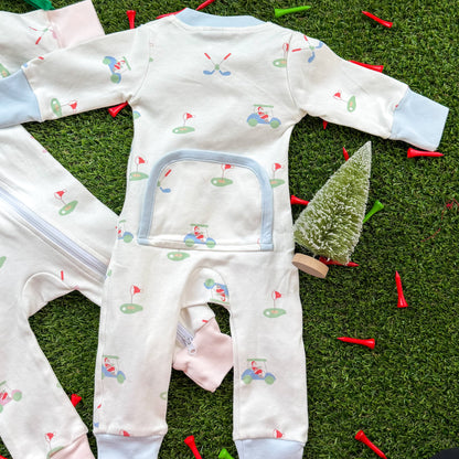 Back view of holiday golf baby onesie with blue trim, two-way zipper, and decorative back panel, displayed on turf with Christmas props.