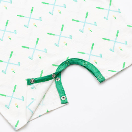 Close up shot of snap closure on white romper with green and blue golf club pattern. Snap closure is green trim.