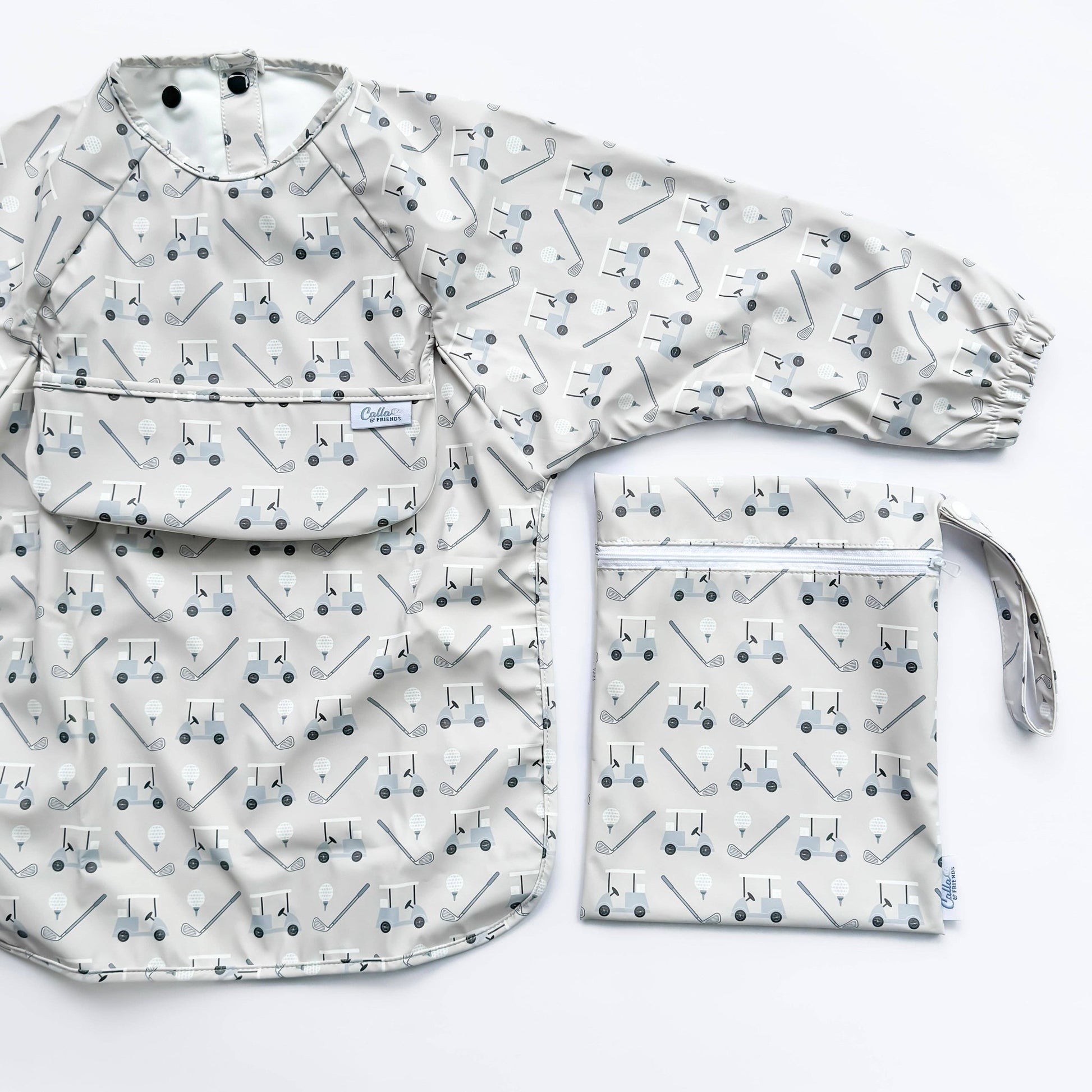 Long sleeved grey bib with golf cart pattern. Shown on a white background with wet/dry bag