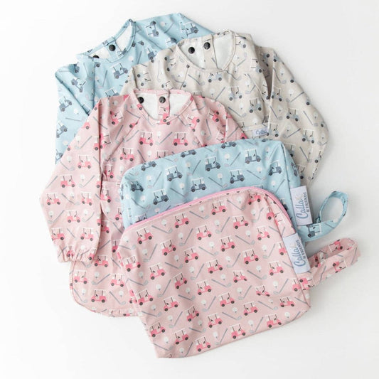 Set of baby bibs with golf cart pattern on them. Pink, blue, and grey bibs shown with wet/dry bags on a white background.
