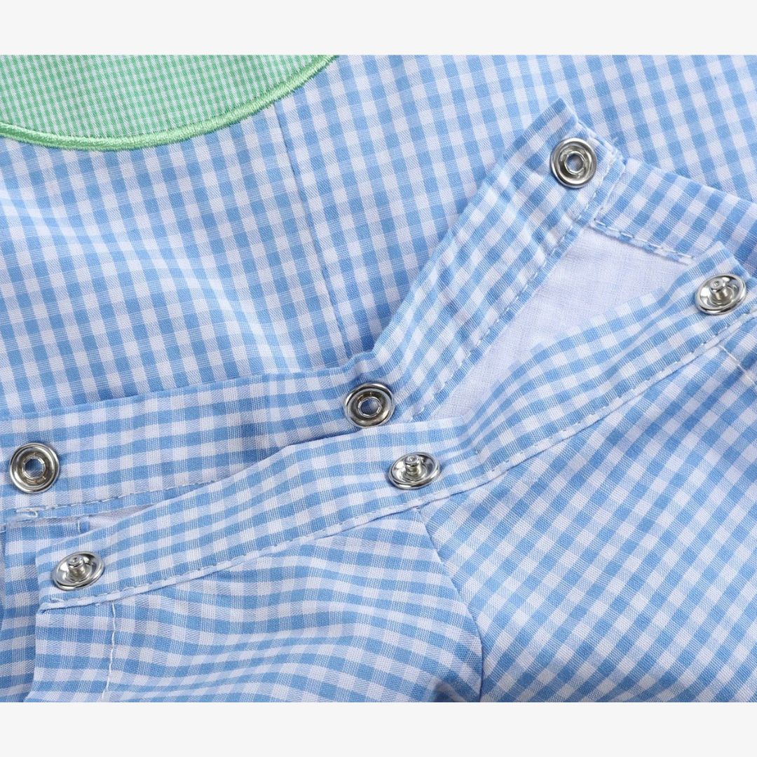 Detail view of snap closures on blue gingham baby golf shortall for easy diaper changes
