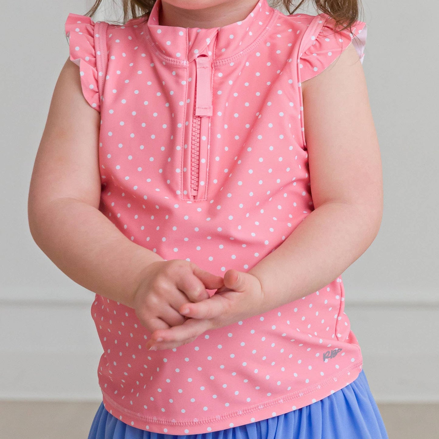 Toddler girl wearing pink polka dot sleeveless top with ruffle shoulders