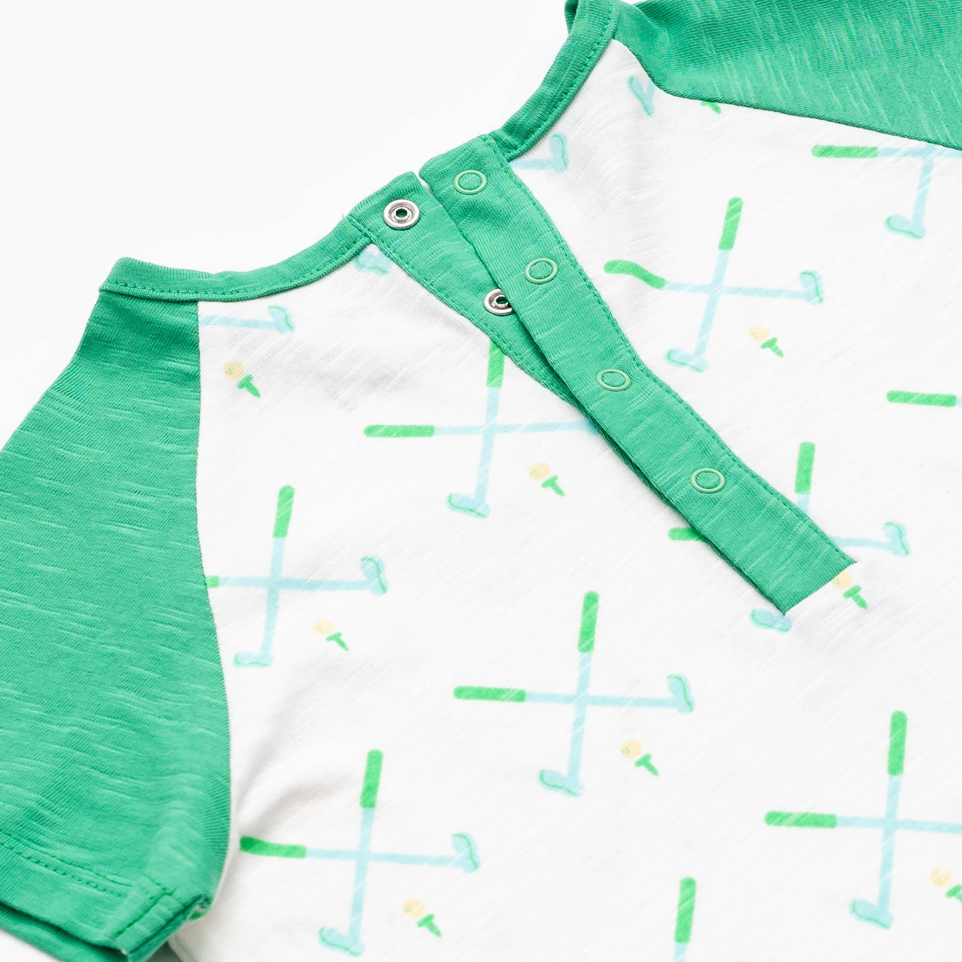 Detail shot of top back of golf pattern romper. Green sleeves and green trim snap detail with 4 snaps down center back. 