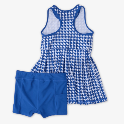 Blue and white houndstooth patterned active dress with racer back with solid blue shorts, displayed on a light gray background.