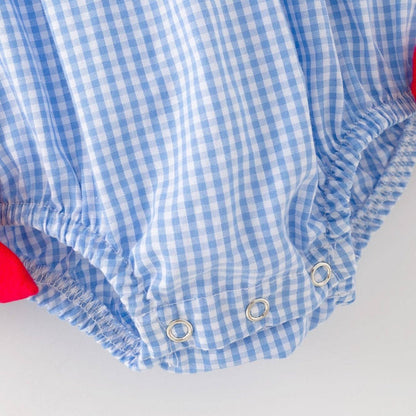 Close-up of snap closure and blue gingham fabric on baby baseball romper
