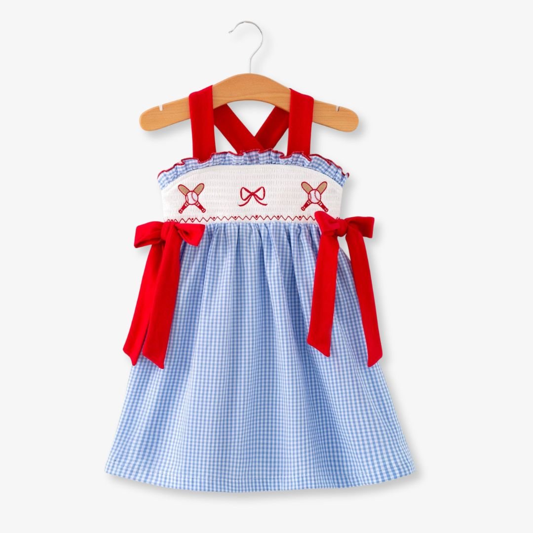 Front view of toddler girls blue plaid baseball smocked dress with red bow details