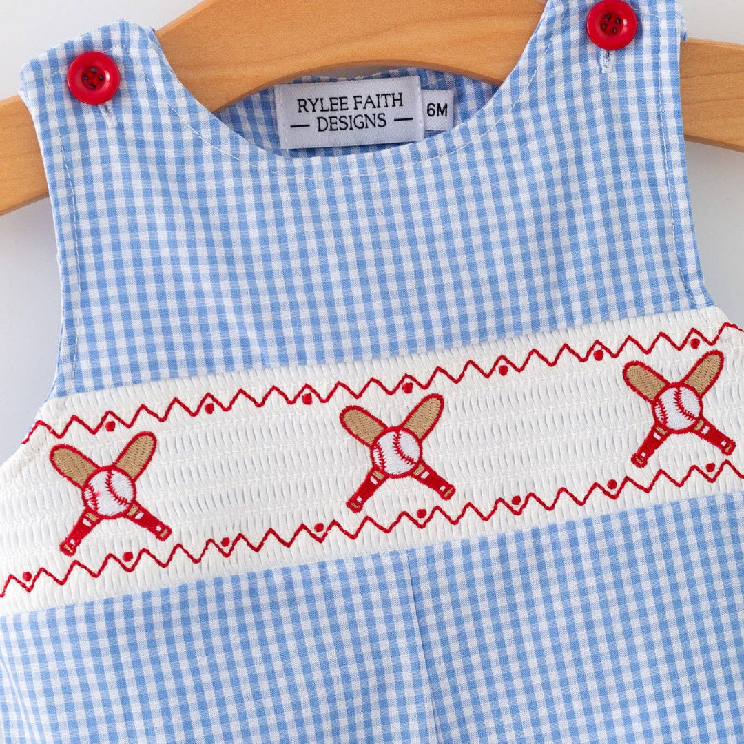 Front close-up of smocked baseball panel on blue plaid baby romper