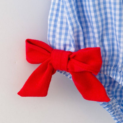 Detail of red bow accent on blue plaid baby girls baseball romper