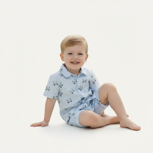 Toddler boy wearing the Tatum Boy Golf Short Set with light blue golf cart print, short-sleeve button-front shirt and matching shorts, photographed on a white background.