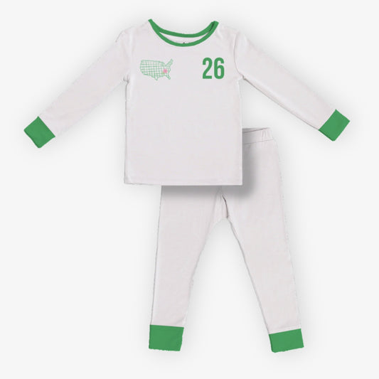 Front of kids white pajama set with green trim featuring “26” and USA golf graphic on the front of the top