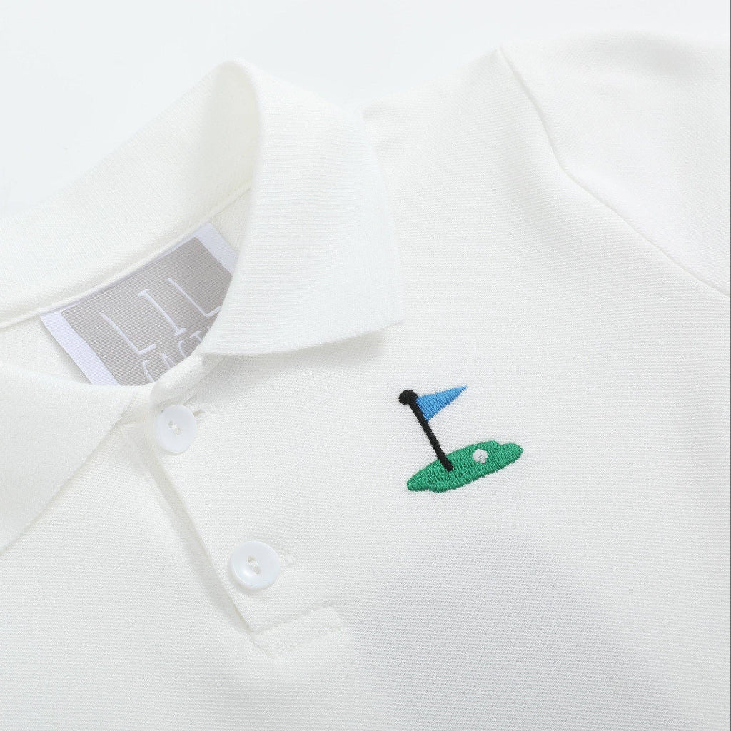 Close-up of embroidered golf pin detail on white kids polo shirt