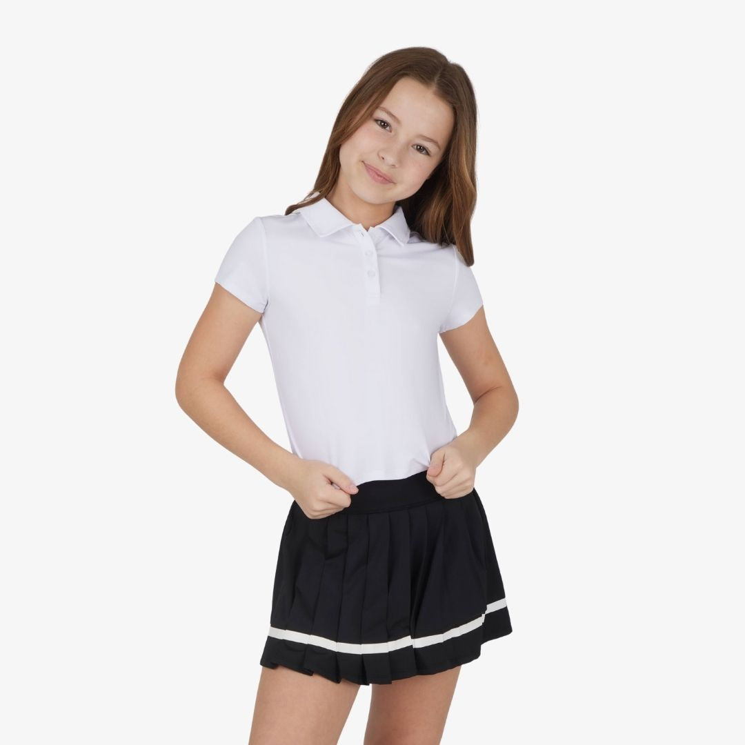 Front view of girls polo top and pleated tennis skort outfit set in white and black