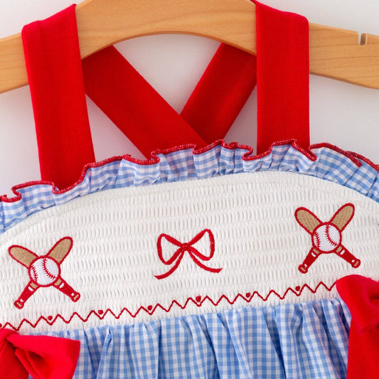 Close-up of smocked baseball embroidery and red bows on toddler girls dress