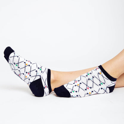 Side view of patterned no-show socks with navy trim and multicolor golf club print, feet stretched out and facing each other