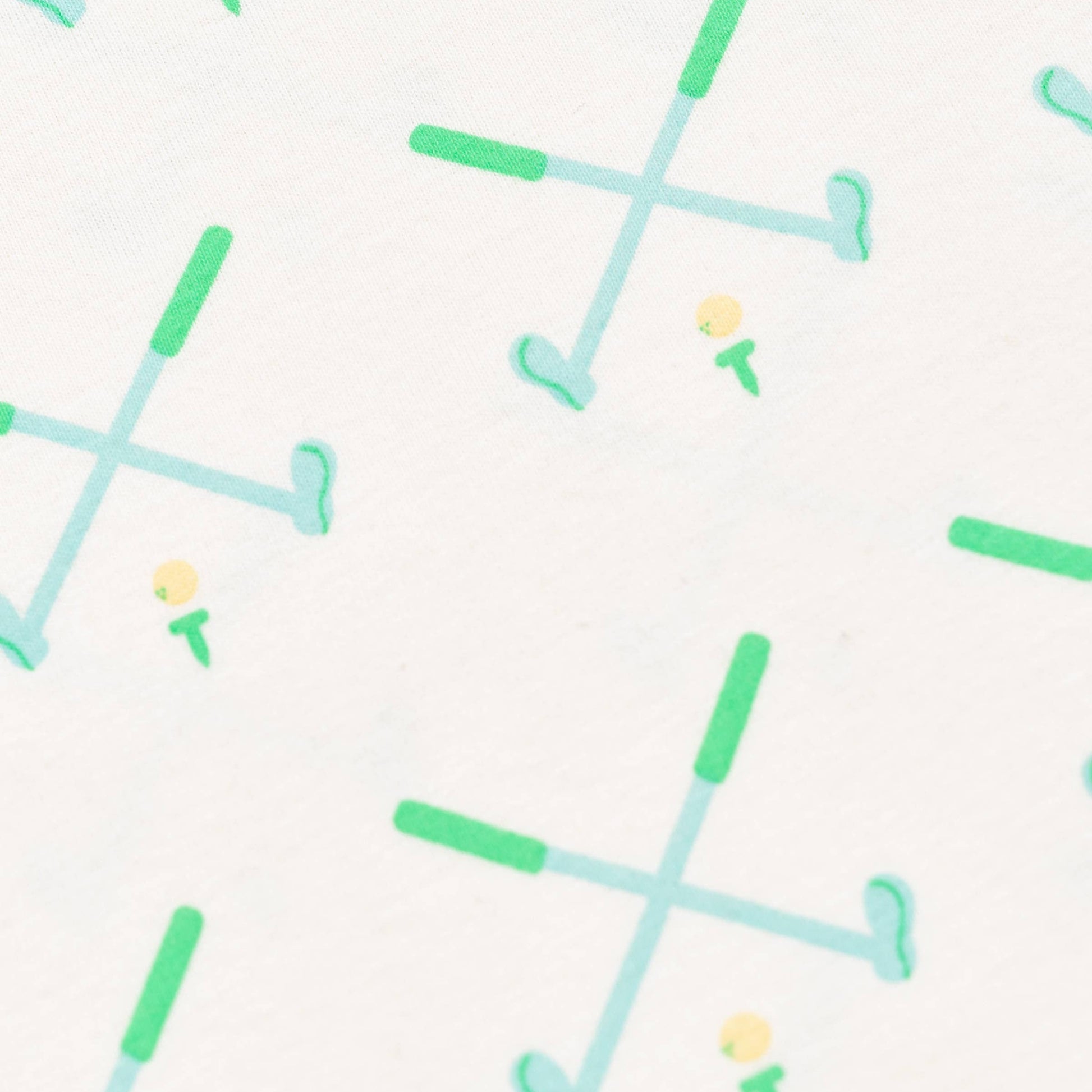 Detail shot of golf pattern. White background, Green and blue golf clubs crossed with yellow golf ball on green tee.