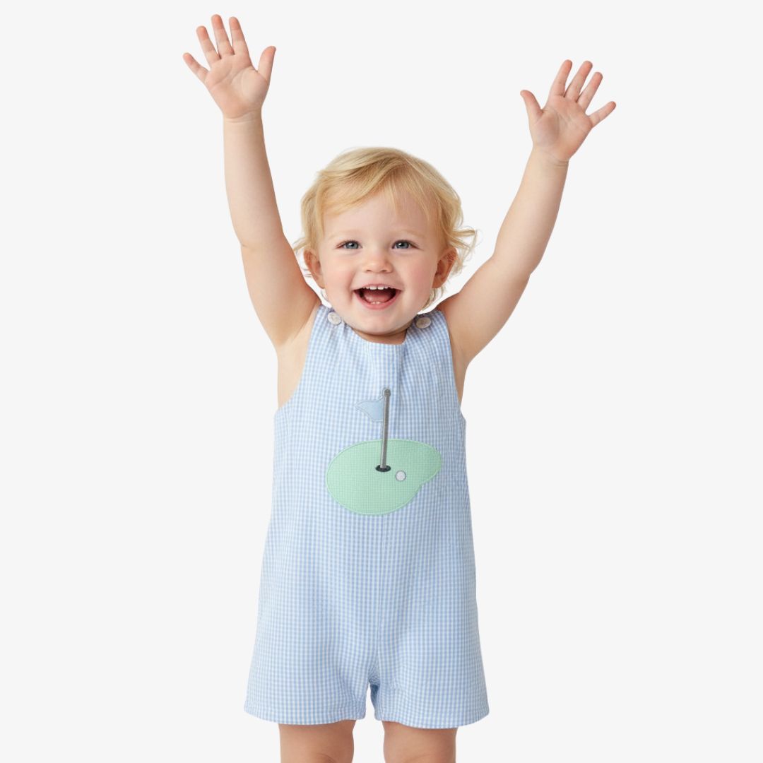 Baby wearing blue gingham golf hole shortall showing fit and movement
