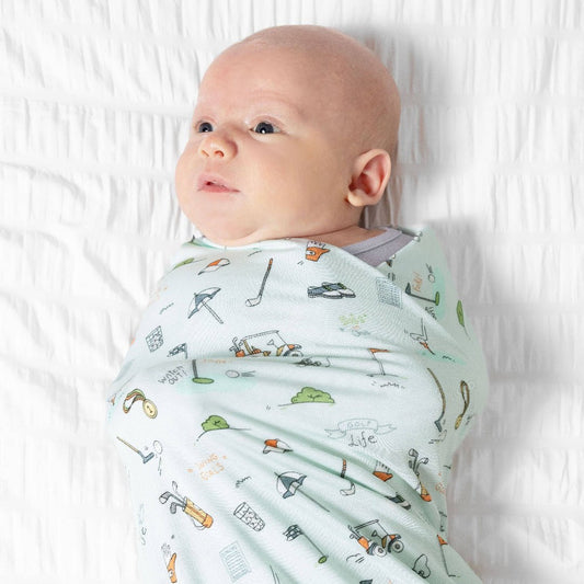 Baby wrapped in light blue swaddle blanket with golf cartoons 