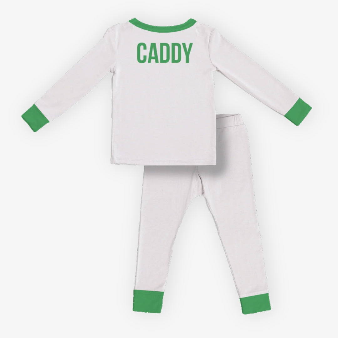 back of kids white pajama set with green trim featuring “CADDY” text on the back of the long sleeve top