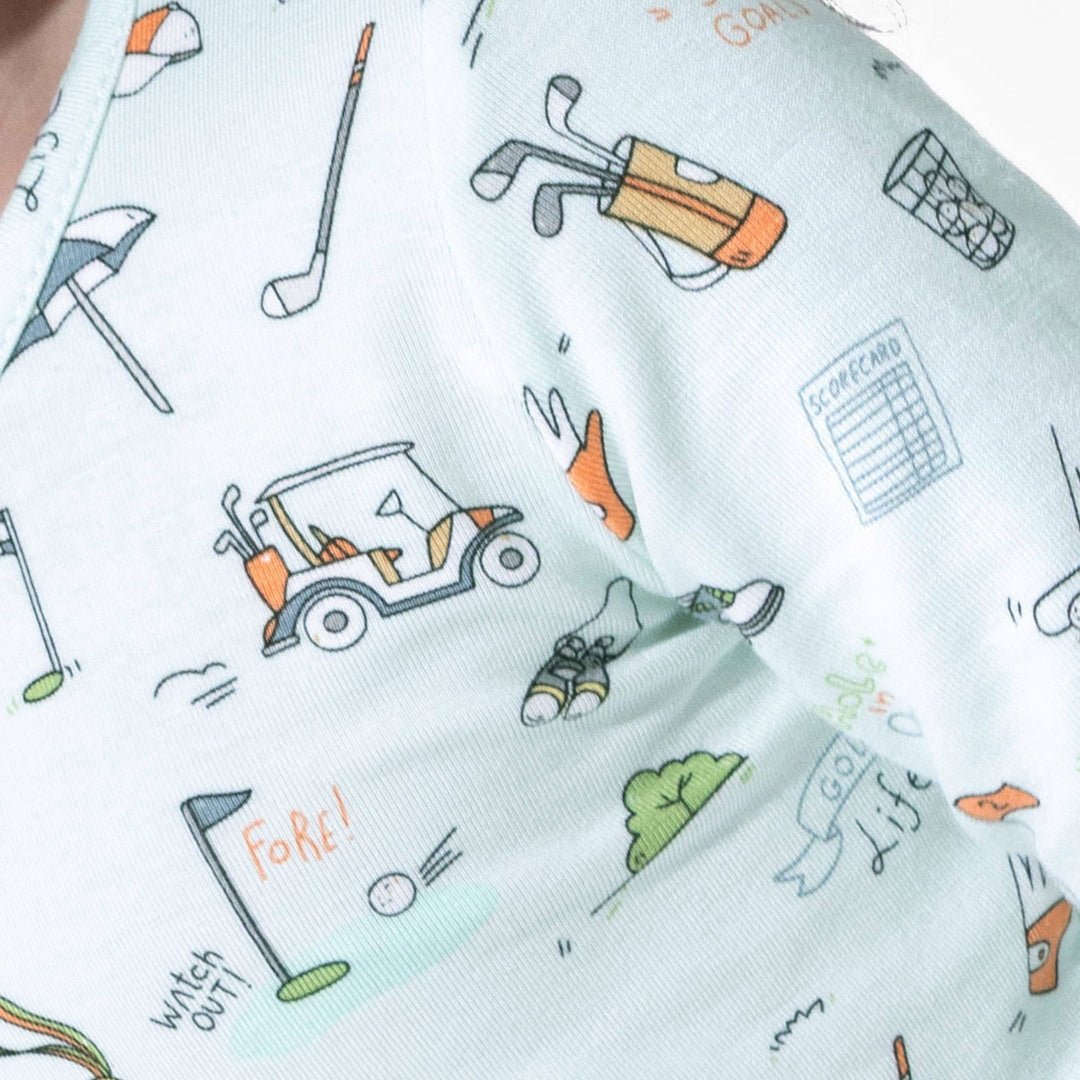 close up shot of kids golf pajamas. Light blue with cartoon golf icons.