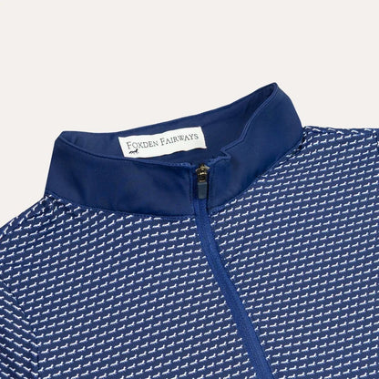 Close-up of a blue and white fox patterned quarter zip with a solid navy collar. The inside collar label reads 'FOXDEN FAIRWAYS'.