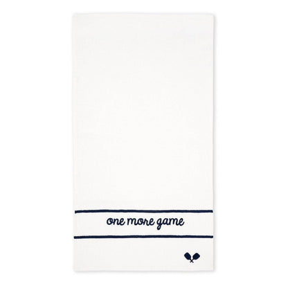 White terry tennis towel with navy embroidered “one more game” text and small crossed racquet icon on a clean background