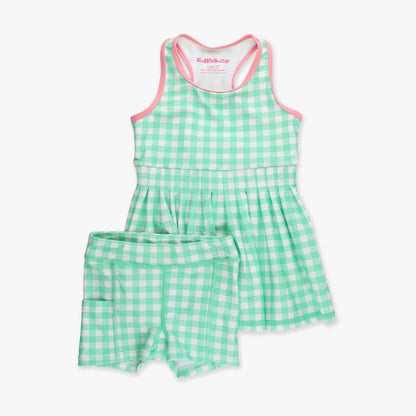 Green gingham pleated active dress with matching bike shorts featuring side pocket, laid flat on white background.