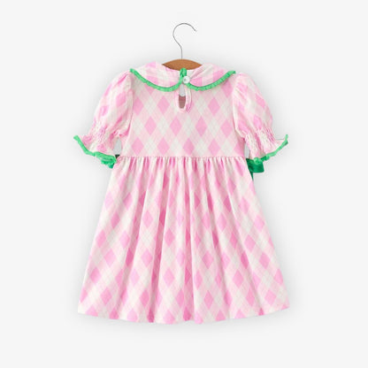 Back view of pink argyle girls dress with smocked sleeves and green trim