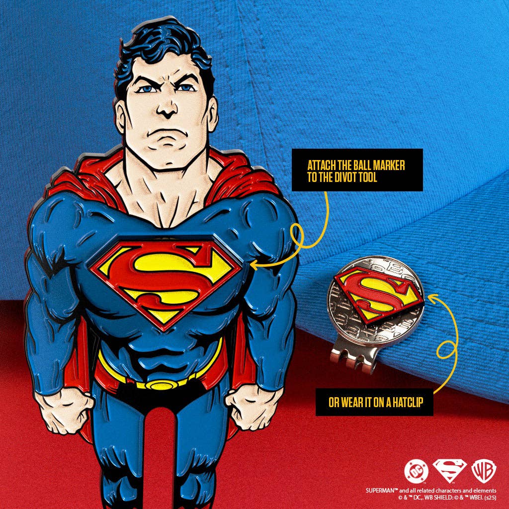 Superman divot repair tool with removable S-Shield magnetic ball marker attached, shown on blue fabric background