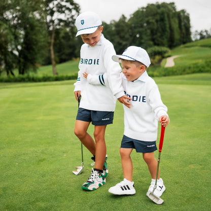 Boy and toddler wearing golf sweater with birdie across chest